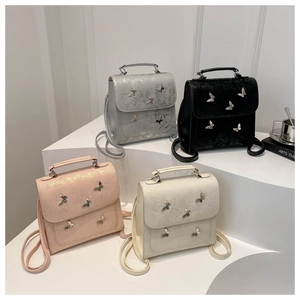 Detailed display of butterfly backpacks in silver, black, pink, and beige colors