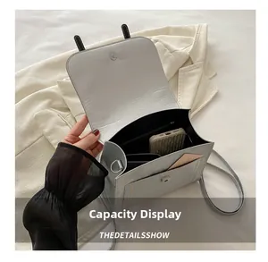 Detailed interior capacity of silver-grey leather shoulder bag showing storage space