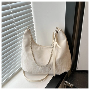Detail of off-white hobo bag showing pleated texture and silver chain strap