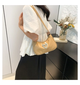 Chic beige heart rhinestone crescent bag worn over shoulder in elegant lifestyle setting