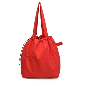 Bright red nylon drawstring tote bag with spacious interior and textured fabric finish