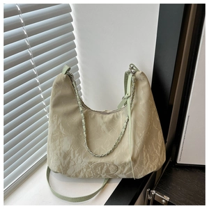 Detail of light green ruched tote bag with silver chain and detachable leather strap