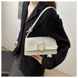 Détail du sac à bandoulière blanc à motif crocodile avec une grande boucle en U dorée