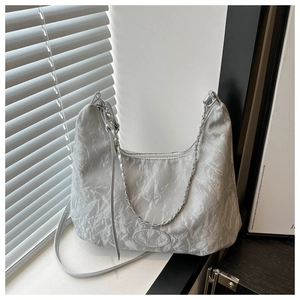 Detailed view of wrinkled silver-gray hobo bag featuring chain strap and hobo silhouette
