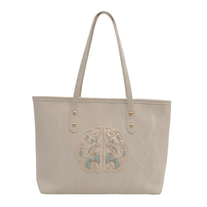 Chic cream tote bag with elegant floral embroidery and gold metal rivets for women
