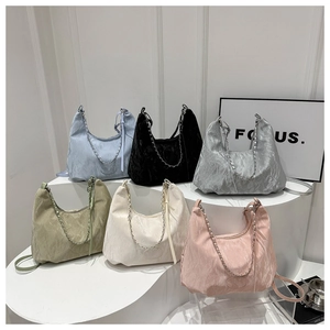 Detailed display of six colorful pleated nylon tote bags with chain straps on a white stand