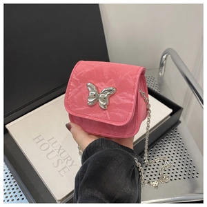 Close-up of pink crinkled leather crossbody bag with silver butterfly metal clasp