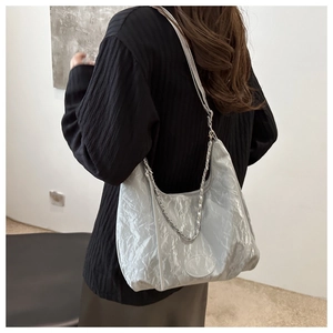 Silver-grey pleated hobo bag detail featuring metallic chain and textured fabric