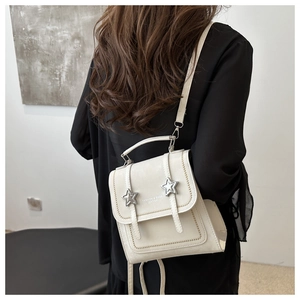 Close-up of white PU leather handbag with silver star studs and elegant top handle