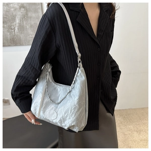 Detail of light blue crinkled metallic shoulder bag with decorative metal chain strap