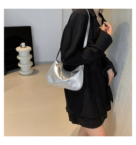 Detailed view of silver hobo bag with a sparkling rhinestone heart on a black outfit
