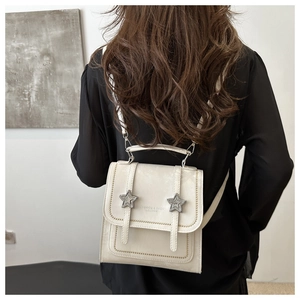 Close-up of a retro beige mini backpack with star buckles and fashion leather logo