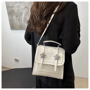 Detail of off-white leather mini backpack with silver star buckles and stitching