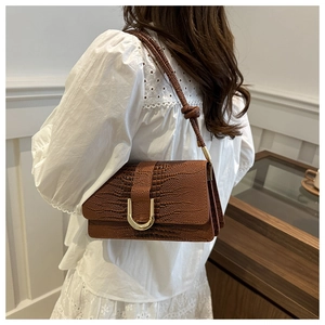 Vue détaillée du sac à bandoulière marron gaufré crocodile avec une boucle en métal doré