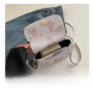 Internal view of a white butterfly print crossbody bag showing storage capacity for wallets