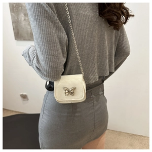 Mini cream leather crossbody bag with silver butterfly buckle shown on model back