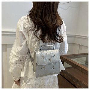 Silver butterfly backpack with glitter texture shown as a stylish crossbody bag