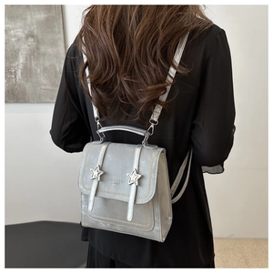 Detail of silver mini backpack with metallic stars and embossed fashion text for women