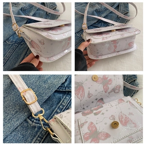 Detail view of butterfly print crossbody bag with magnetic closure and golden hardware