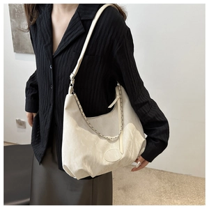 Off-white pleated hobo bag with leather strap and silver chain shown on a model