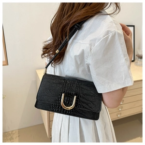 Détail du similicuir noir à texture crocodile avec boucle de fermeture dorée en forme de U