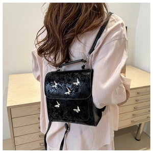 Detail of black butterfly backpack with silver metallic accents on textured faux leather