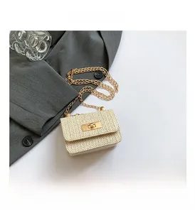 Close-up of woven straw texture with gold chain strap and metal turn-lock closure