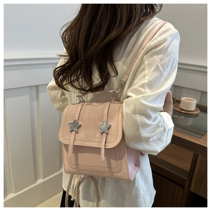 Close-up of pink leather mini backpack with star charms and fine stitching details