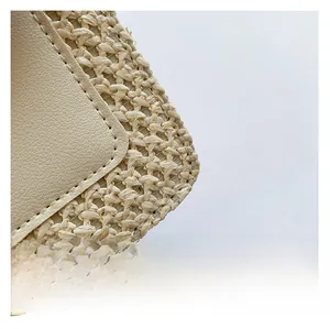 Close-up of natural straw weave texture and matching lychee leather stitching on handbag