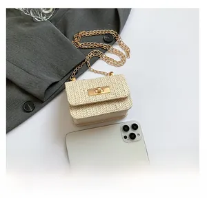Mini beige woven crossbody bag with gold lock compared to a smartphone for size