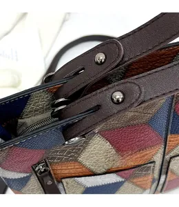 Detail of reinforced gunmetal hardware and geometric textured leather on a tote bag