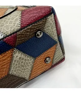 Detailed macro of the leather tote corner with multicolored patches and silver metal studs