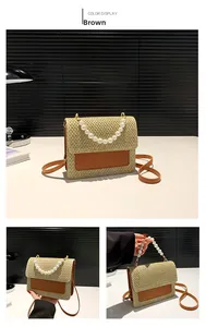 Detail of woven straw handbag featuring pearl handle and brown leather trim details