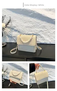 Detail view of white woven crossbody bag with elegant pearl handle and flap closure