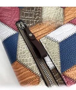 Detailed close-up of colorful patchwork leather tote bag featuring a front metal zipper