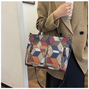 Close-up of a 3D geometric patchwork tote bag with litchi texture on a female model