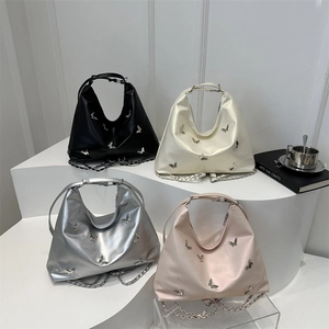 Multi-color hobo bags with metallic butterfly studs and chain straps on display