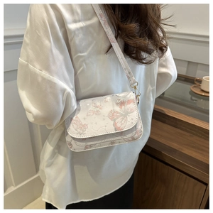 Detail of crossbody bag featuring delicate pink butterfly prints and star patterns