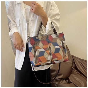 Macro detail of geometric color block tote bag featuring multi-color leather paneling