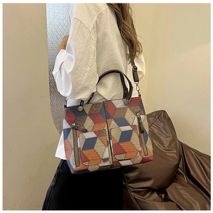 Detail of colorful geometric cube pattern and pockets on textured faux leather tote bag