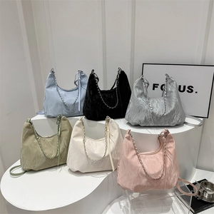 Chic pleated tote bags with chain straps in six colors on minimalist podiums