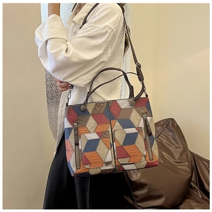 Detailed view of retro geometric patchwork tote with leather texture and zip pockets