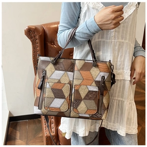 Detail of geometric 3D cube patchwork tote bag featuring textured leather and dual zip pockets