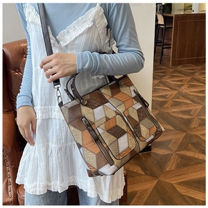 Detail of geometric pattern tote bag featuring vintage leather handles and shoulder strap
