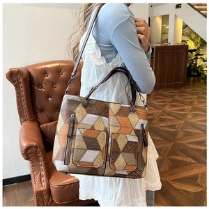 Detail of color-block tote bag with 3D geometric pattern and premium hardware