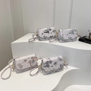 Collection of summer trendy crossbody bags with butterfly prints on white display stand