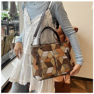 Detail of geometric patchwork tote bag with 3D cube pattern and textured faux leather