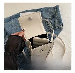 Internal view of mini white crossbody bag showing storage capacity for a smartphone