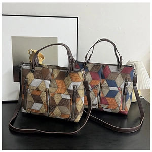 Detail of textured PU leather tote bag with geometric 3D patterns and dual zipper pockets