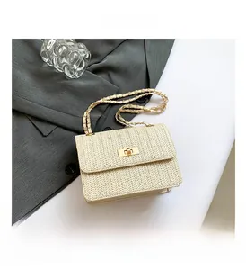 Détail du tissage beige, du fermoir tournant doré et de la bandoulière chaîne du sac à main